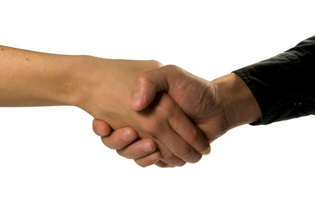 Two people shaking hands over a deal